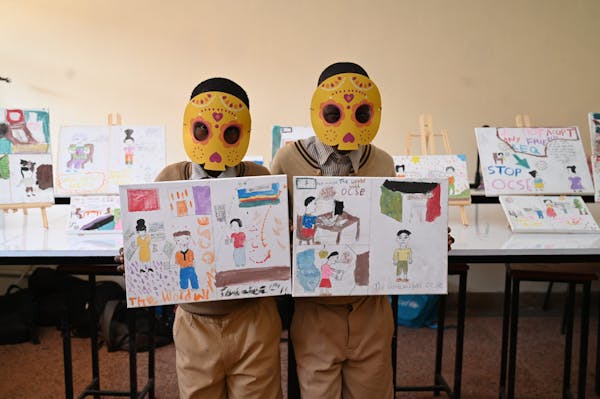 Two boys showcasing their art projects.