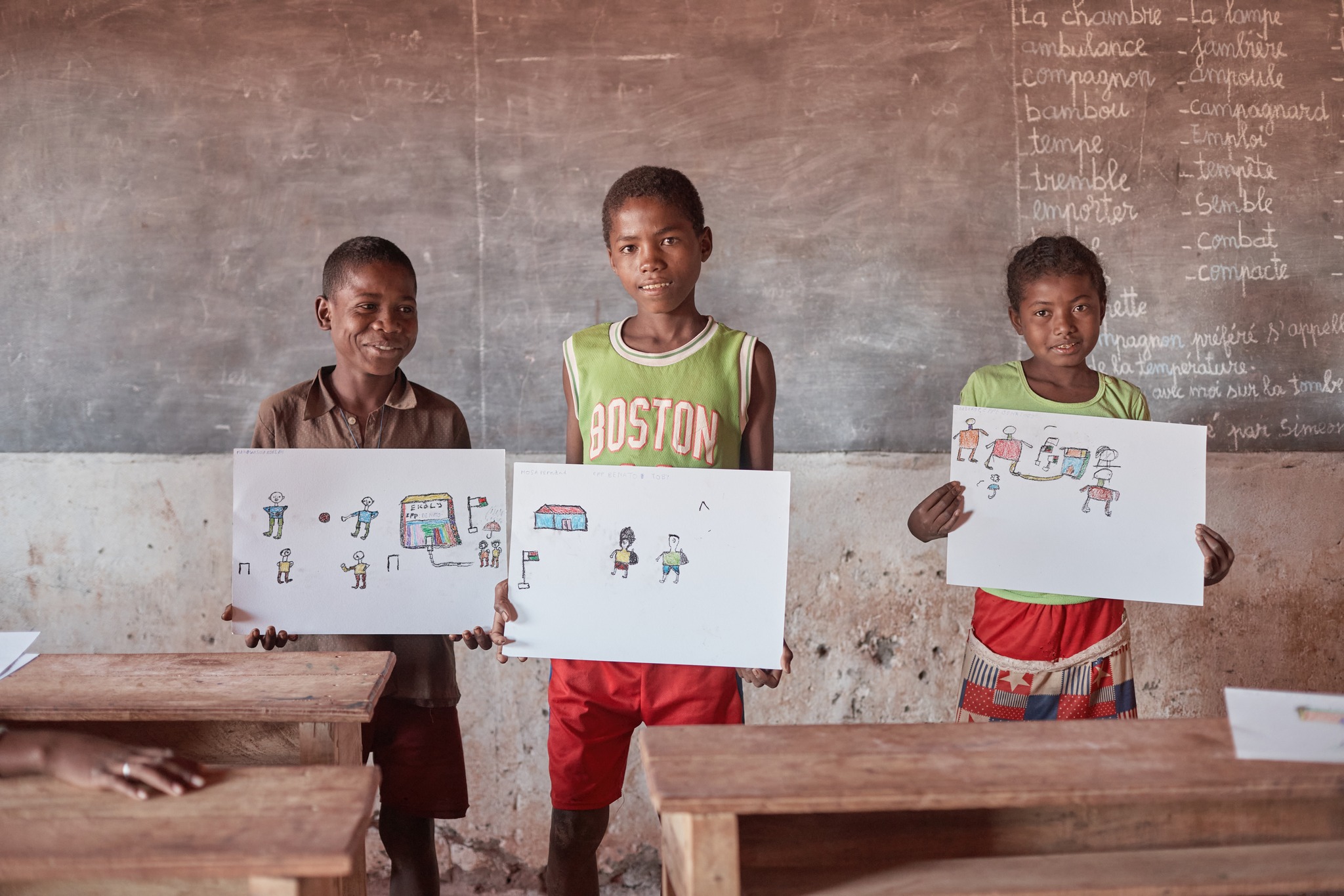 Children holding drawings during the art event in Madagascar