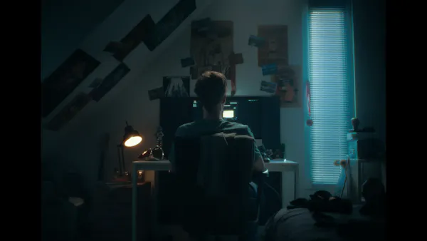 Boy behind laptop is typing prompts for AI nude images