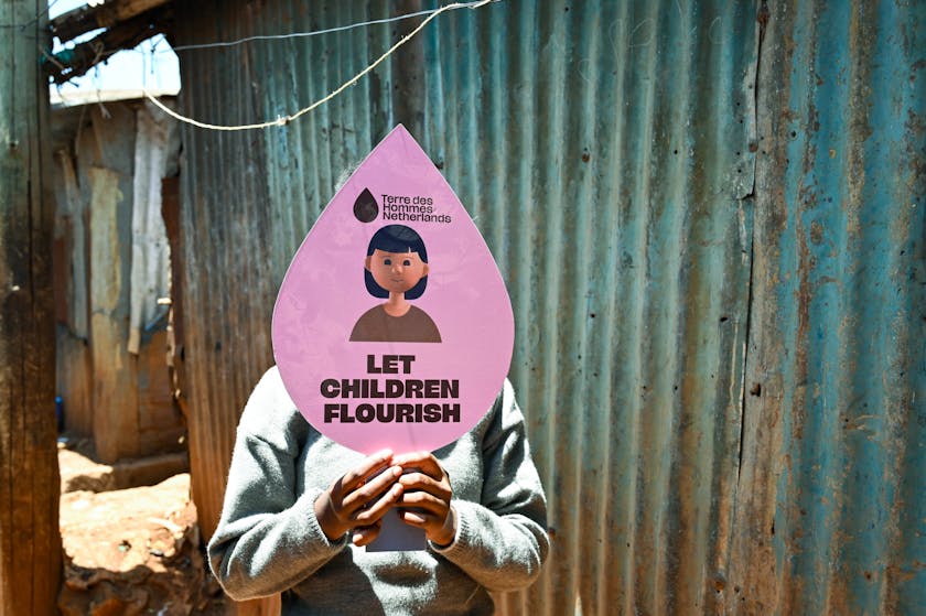 Bianca*, 13 years old, a project participant of the SCROL programme in Nairobi, Kenya, photographed holding a placard with the message ´Let children flourish´. Photo credit: Terre des Hommes Netherlands.
