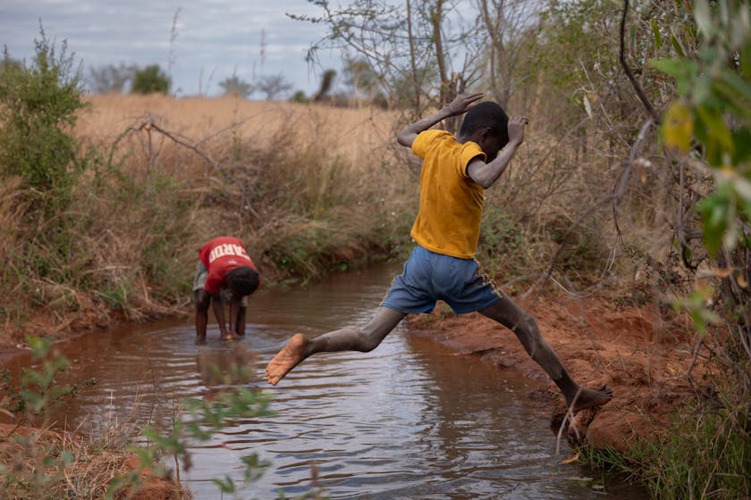Lahiandro, a 14-year-old boy, leaps over an irrigation canal in the fields near his home. Photo credit: Safidy Andrianantenaina